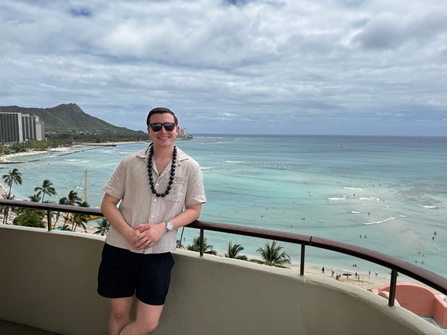 Austin Hunt on a balcony overlooking Waikiki beach and Diamond Head
