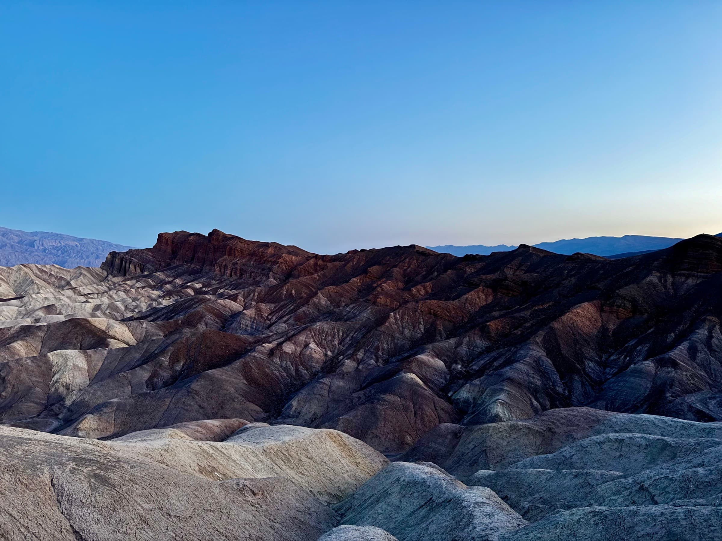 A mountain ridgeline at dusk, Austin's own photograph and the source of the brand palette